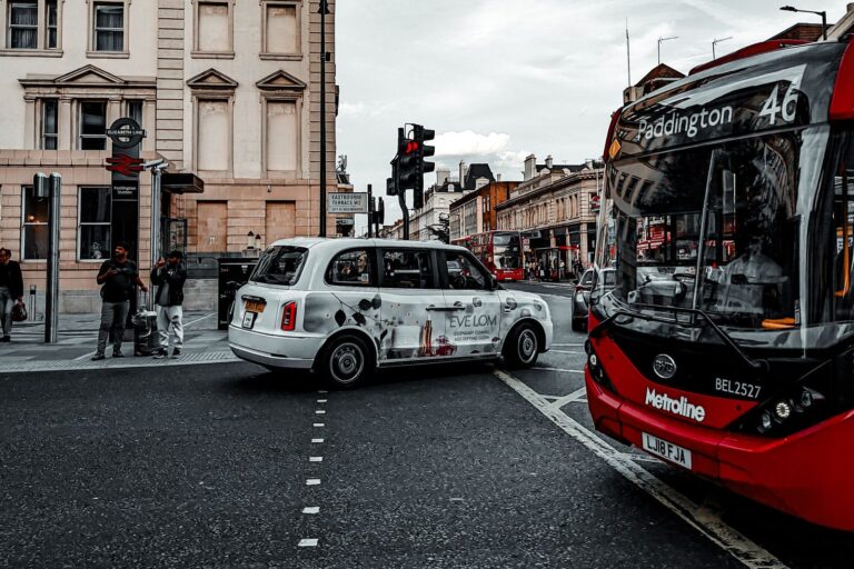 Red bus and white taxi at a London road junction