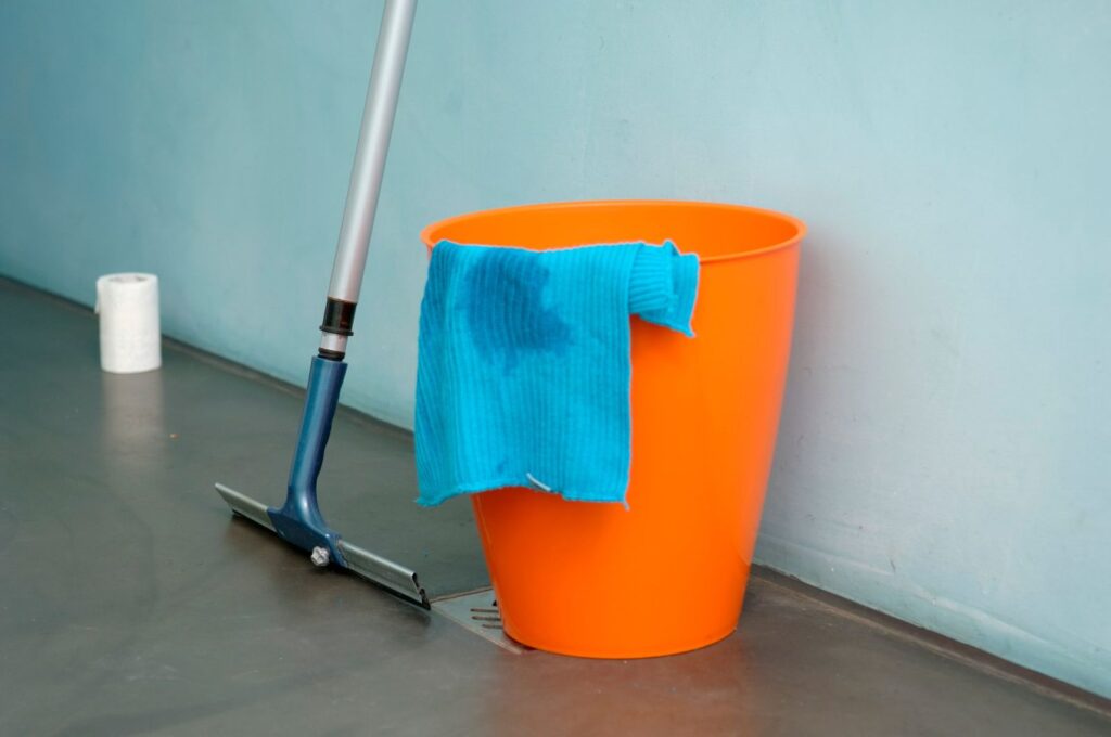 Orange bucket with a blue cloth and a floor squeegee
