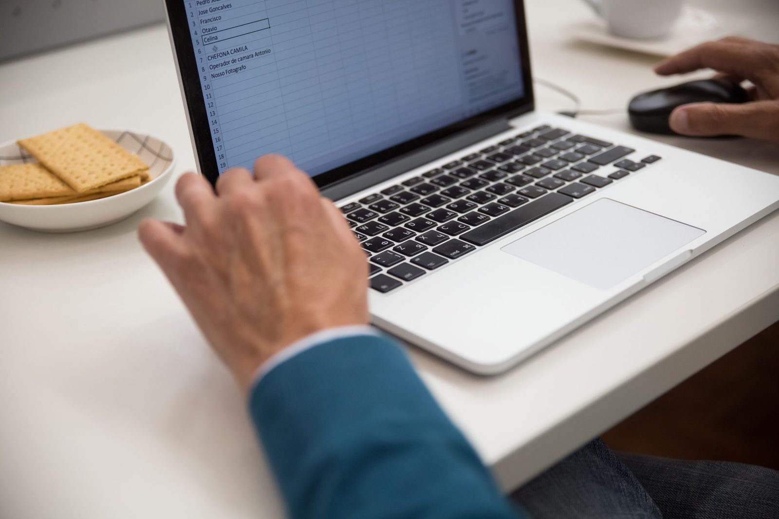 A person working on a spreadsheet on a laptop at a desk