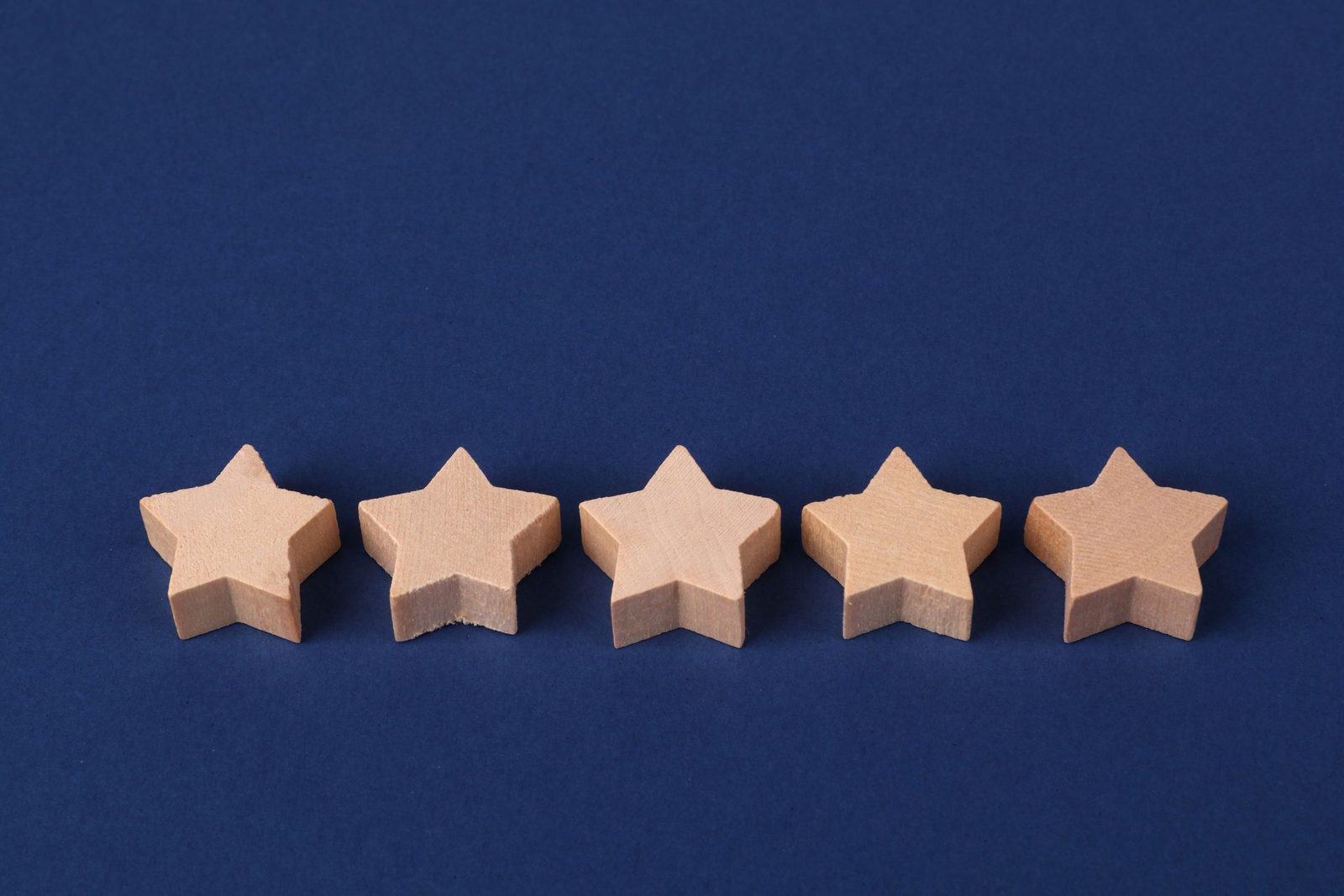 Five wooden stars in a row on a dark blue background
