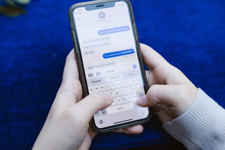 Hands holding a smartphone showing a text message conversation